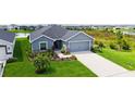 Charming single Gathering home featuring a two-car garage and a beautifully landscaped front yard at 6435 165Th E Dr, Parrish, FL 34219