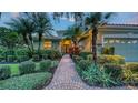 Charming home featuring lush landscaping, brick walkway, and a well-maintained exterior at 7012 Treymore Ct, Sarasota, FL 34243