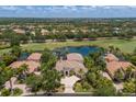 Luxury single-story home with a tile roof, lush landscaping, water view, and close proximity to golf course at 7211 Pasadena Gln, Lakewood Ranch, FL 34202