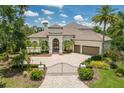Stunning single-story home boasts an arched entryway, tile roof, a two-car garage, and meticulously manicured landscaping at 7211 Pasadena Gln, Lakewood Ranch, FL 34202