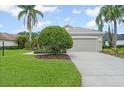 Two car garage with driveway, mature landscaping, and a well-maintained lawn at 7424 Sea Island Ln, Bradenton, FL 34201
