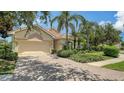 Charming single-story home boasts mature landscaping, a tile roof, and a brick driveway at 7717 Us Open Loop, Lakewood Ranch, FL 34202