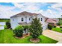 Beautiful exterior view of a two-story home with lush landscaping, and a well-manicured lawn at 7930 111Th Ter E, Parrish, FL 34219