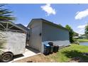 Detached garage with a white door, blue siding, and a trailer alongside at 9007 63Rd Avenue E Dr, Bradenton, FL 34202