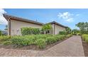 Beautiful landscaping surrounding home exterior with brick walkway at 10254 Morning Mist Ln, Sarasota, FL 34241