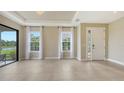 Bright living room with tile flooring, large windows overlooking the lake at 10254 Morning Mist Ln, Sarasota, FL 34241