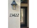 Close-up of the home's address and a stylish outdoor light fixture near the front door at 13422 Saw Palm Creek Trl, Lakewood Ranch, FL 34211