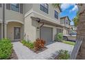 Close-up exterior of townhome showing a stone driveway and entry with beautiful plants at 15131 Sunny Day Dr, Bradenton, FL 34211