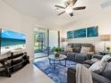 Comfortable living room with a plush gray sofa, ocean-themed art, and sliding door access to patio at 17612 Northwood St, Lakewood Ranch, FL 34202
