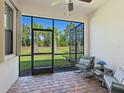 Screened-in patio featuring brick flooring, ceiling fan, and comfortable seating, perfect for relaxation at 17612 Northwood St, Lakewood Ranch, FL 34202