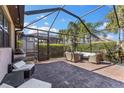Enjoy outdoor living on the screened patio with comfortable seating and a view of the surrounding greenery at 19023 Mangieri St, Venice, FL 34293