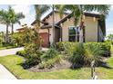 Beautifully landscaped home exterior with lush tropical plants and well-maintained lawn at 201 Vinadio Blvd, Nokomis, FL 34275