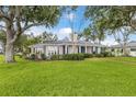 Charming one-story home with lush landscaping and a well-manicured front lawn at 2401 Riverview Blvd, Bradenton, FL 34205