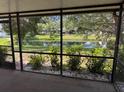 Relaxing screened-in porch with serene views of the backyard pond and lush landscaping at 3404 56Th Dr E, Bradenton, FL 34203