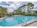 Large community pool with lounge chairs and mature trees surrounding the area at 3617 Yellow Pine Ct # 144, Sarasota, FL 34238