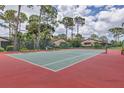 Inviting tennis court surrounded by lush greenery and mature trees at 3617 Yellow Pine Ct # 144, Sarasota, FL 34238