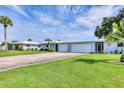 Single-story home featuring a well-manicured lawn, lush landscaping, and a two-car garage at 3721 Somerville Dr # 1513, Sarasota, FL 34232