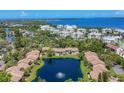 Aerial view of community homes surrounding the serene lake with fountain and ocean view at 3810 75Th W St # 128, Bradenton, FL 34209