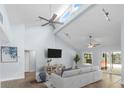 Bright living room with vaulted ceilings, tile floors, ceiling fans, and a sliding door to the backyard at 3915 Meadow Creek Dr, Sarasota, FL 34233