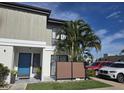 Inviting condo exterior with a bright blue door, neutral siding, privacy fence, and lush landscaping at 4001 Beneva Rd # 319, Sarasota, FL 34233