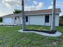 Attractive single-story home with a well-manicured lawn and charming landscaping beds along the front at 481 Saturn Ave, Sarasota, FL 34243