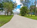 Long driveway leading to a well-maintained single-story home surrounded by mature trees and lush landscaping at 601 136Th St E Ct, Bradenton, FL 34212