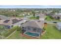 A beautiful home featuring a screened-in pool surrounded by a well-manicured lawn at 6266 Buckingham St, Sarasota, FL 34238