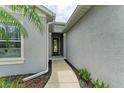 Inviting front entrance with a well-maintained walkway and neutral exterior paint at 6516 Palm Leaf Ct, Sarasota, FL 34243