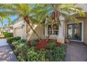 Close-up of the home's entrance, showcasing elegant columns, lush landscaping, and a beautiful front door at 7615 Charleston St, Bradenton, FL 34201