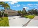 Inviting home exterior featuring a well-maintained lawn, mature landscaping, and a long driveway at 7615 Charleston St, Bradenton, FL 34201