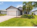 Beautiful single-Gathering home with a brick driveway and lush green lawn surrounded by tropical plants at 7758 Summerland Cv, Bradenton, FL 34202