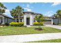 Inviting single-story home featuring a well-maintained lawn and tropical landscaping at 918 Fernleaf Run, Bradenton, FL 34212