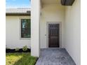 Close-up of the home's front door, showcasing a dark-colored door and neutral color scheme with paver walkway at 1532 Maricopa Rd, North Port, FL 34287