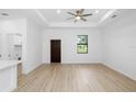 Bright living room features a ceiling fan, recessed lights, wood-look flooring, and a door for easy access at 1532 Maricopa Rd, North Port, FL 34287