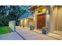 Inviting home entrance with custom wood door, landscape features, custom concrete planters, and accent lighting at 1627 Peregrine Point Ct, Sarasota, FL 34231