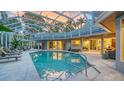 Screened pool with several seating areas, a built-in kitchen bar and a screened enclosure with sunset reflections at 1627 Peregrine Point Ct, Sarasota, FL 34231