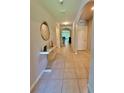 Inviting tiled hallway featuring decorative table and a view of the living area at 1646 Pierpoint St, North Port, FL 34288