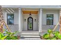 Beautiful home entrance featuring a decorative black door, wood ceiling, and stylish sconces at 1658 Bonita Ln, Sarasota, FL 34239