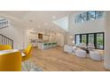 Bright living room with an open floor plan, chef's kitchen, expansive windows, and light hardwood floors at 1658 Bonita Ln, Sarasota, FL 34239