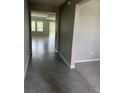 An interior view of a beautifully tiled entrance hallway leading to a spacious living area with large windows at 17637 Cantarina Cv, Bradenton, FL 34211