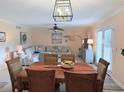 Cozy dining room features a wood table, seating for six, and a modern light fixture, perfect for Gathering meals at 1959 Toucan Way # 206, Sarasota, FL 34232