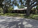 Charming stone-faced home with mature trees and a well-maintained front yard at 211 55Th Nw St, Bradenton, FL 34209