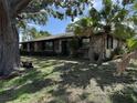 Single story home with stone facade, mature trees, and lush lawn at 211 55Th Nw St, Bradenton, FL 34209