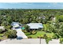 An aerial view showcases this property's pool, carport, lush surroundings and privacy at 2321 Milford Cir, Sarasota, FL 34239