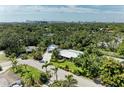 An aerial view that shows city and distant waterways behind the lush surroundings of this property at 2321 Milford Cir, Sarasota, FL 34239