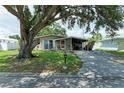 Traditional single-story house with a covered driveway near the entrance, surrounded by mature trees at 3307 Miami Pl, Bradenton, FL 34207