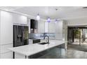Modern kitchen with sleek white cabinetry, stainless steel appliances, and a large island at 3525 Riviera Dr, Sarasota, FL 34232