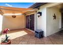 A cozy tiled courtyard with a retractable awning, outdoor lighting, and convenient hose storage at 3615 Puerta Ct # 8516, Sarasota, FL 34232