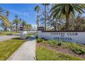 Community entrance sign surrounded by lush landscaping and mature palm trees, showcasing the neighborhood's charm at 3636 Torrey Pines Blvd, Sarasota, FL 34238