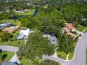 Aerial view of a property surrounded by lush greenery, water and neighborhood, offering privacy and a serene setting at 3900 Country View Dr, Sarasota, FL 34233